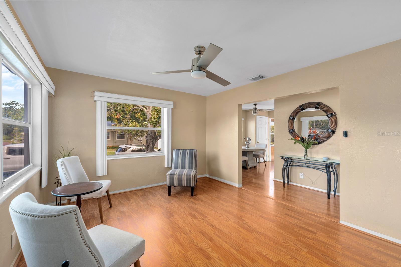 Step into a sunlit living room featuring gorgeous flooring and windows that let in plenty of natural light
