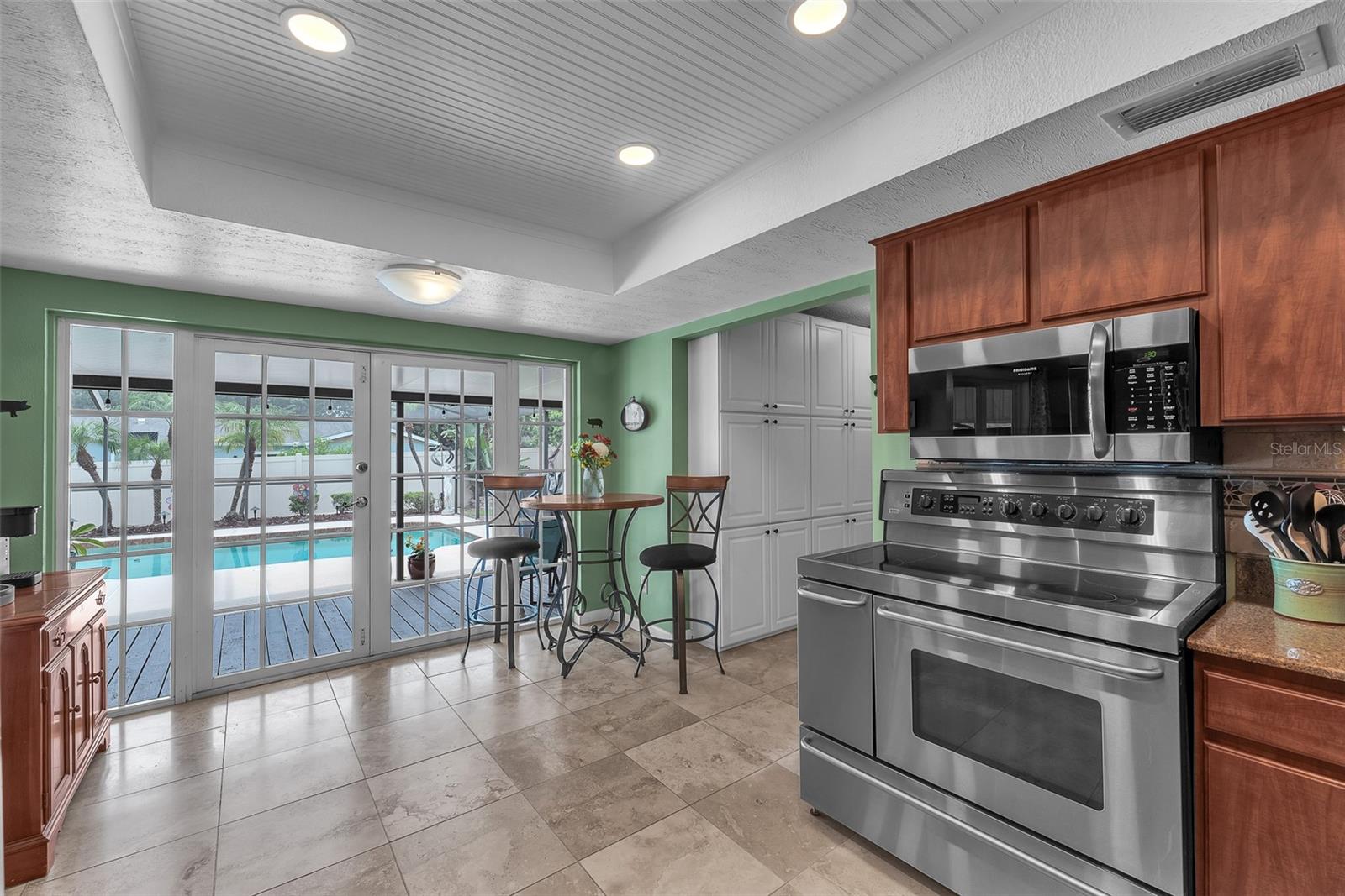 The kitchen has room for casual dining and access to the back screened in porch making indoor/outdoor entertaining effortless.  In the hallway connecting the kitchen to the garage, there is a recently added wall of stacked cabinets for additional pantry storage.