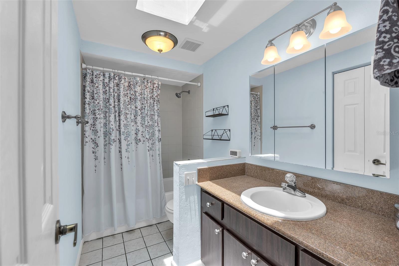 Bathroom #3 on the upper level has a large vanity with granite top and a tub/shower combination plus a large sky light above.