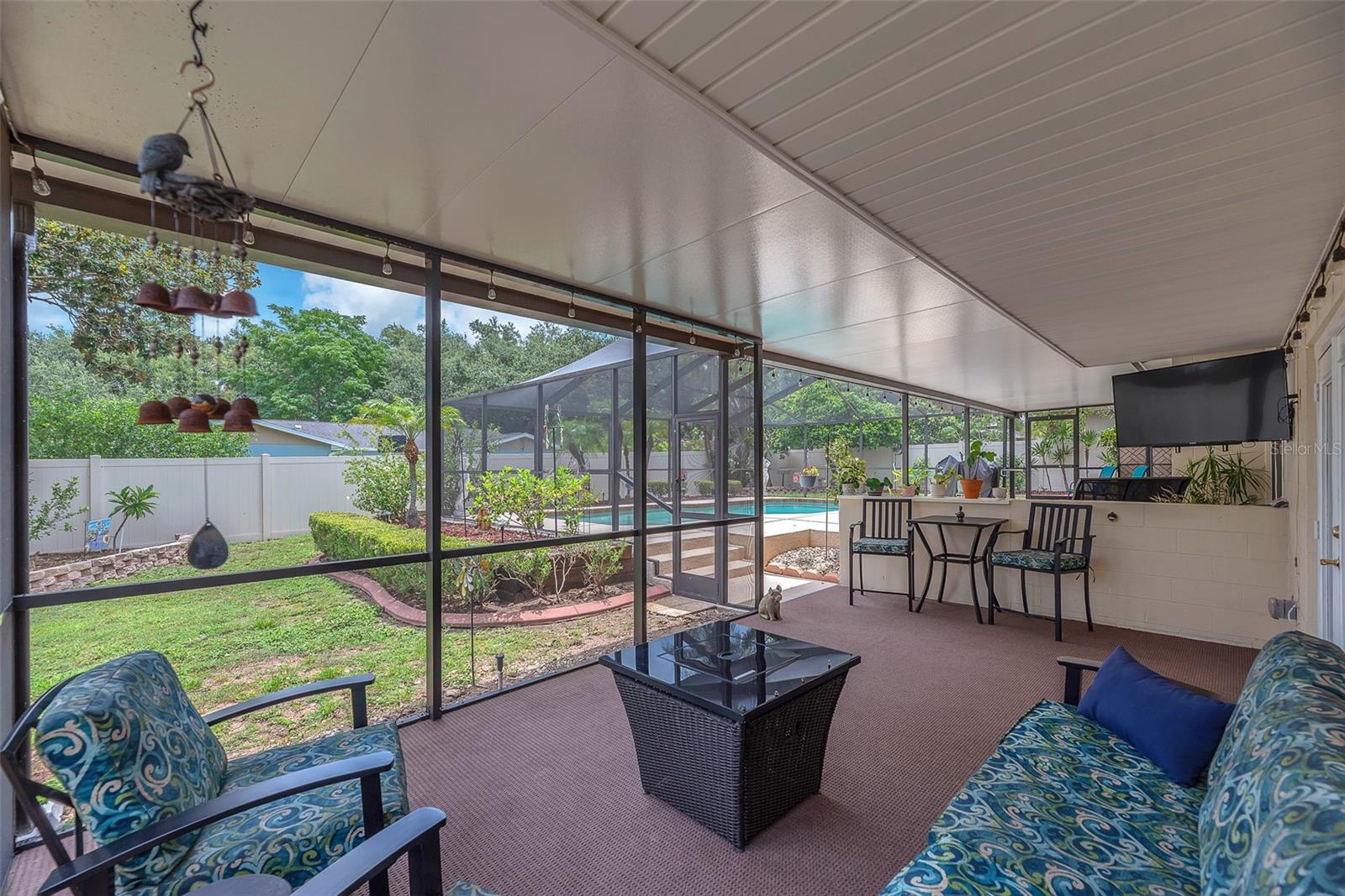 The lower back porch also has access to the backyard and pool and features outdoor carpeting. This area is separately defined yet connected to the upper porch under the same ceiling.
