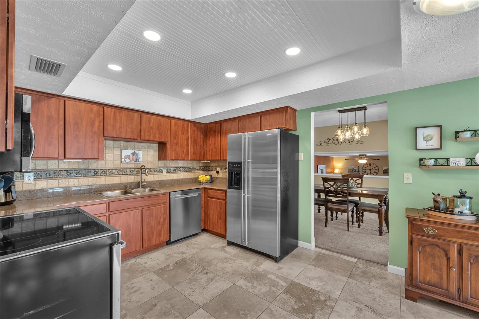 The eat-in kitchen boasts granite countertops, upgraded stainless steel appliances, stylish bead-board ceiling, and ample cabinet space.