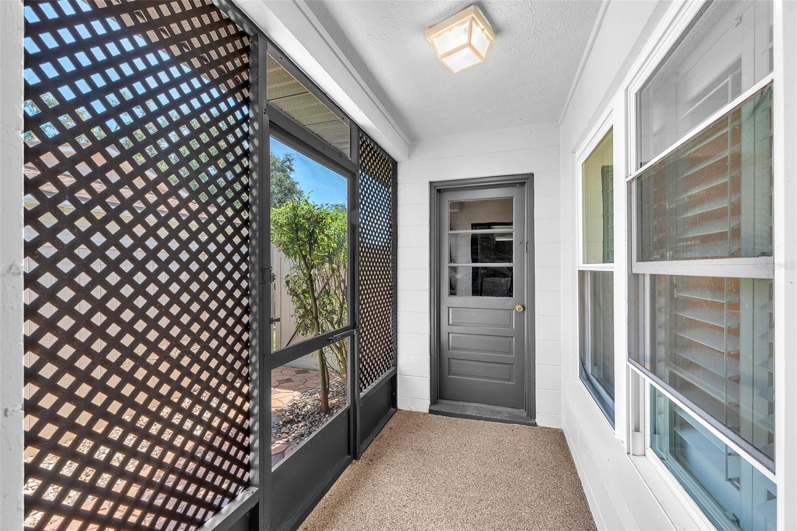 A unique breezeway connects the utility room to the 2-car garage, featuring a screen door that opens to the side yard and a gated walkway leading to the front of the home.