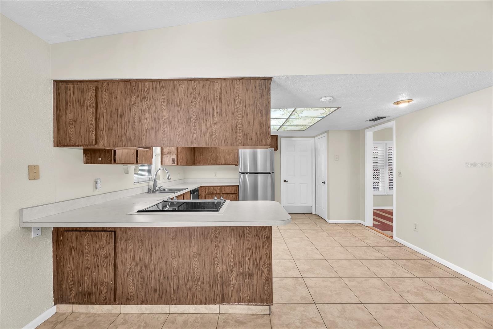 The kitchen includes a closet pantry, with direct access to the utility room and 2-car garage, along with a convenient doorway leading into the dining room.