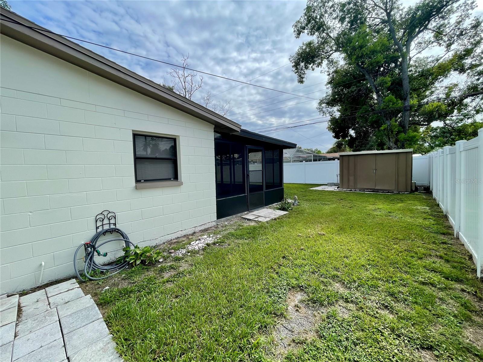 Side yard, Florida room shown here and the shed. White privacy fence around the backyard
