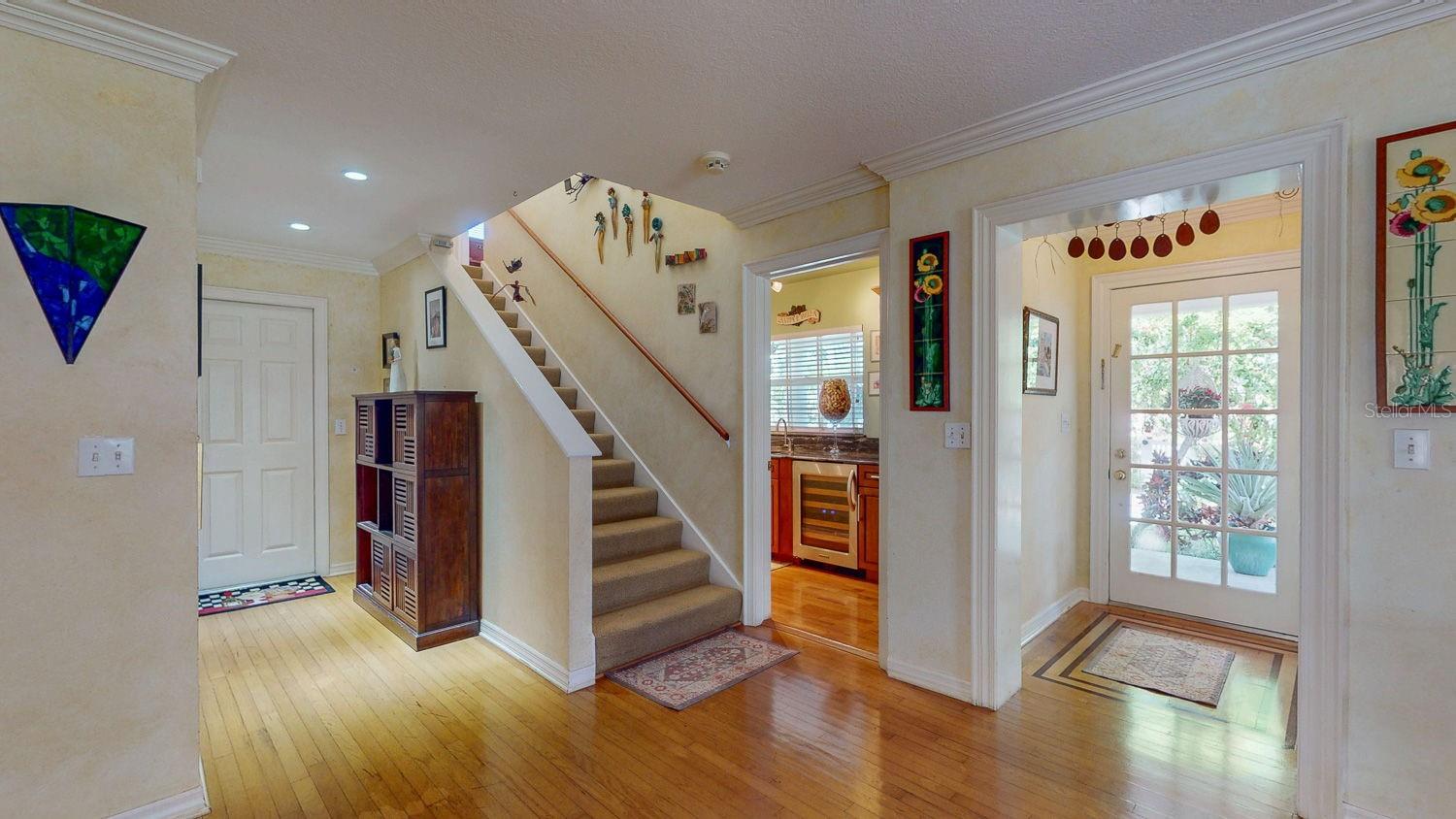 Front door with entrance to wet bar, stairs to second floor and door to garage!