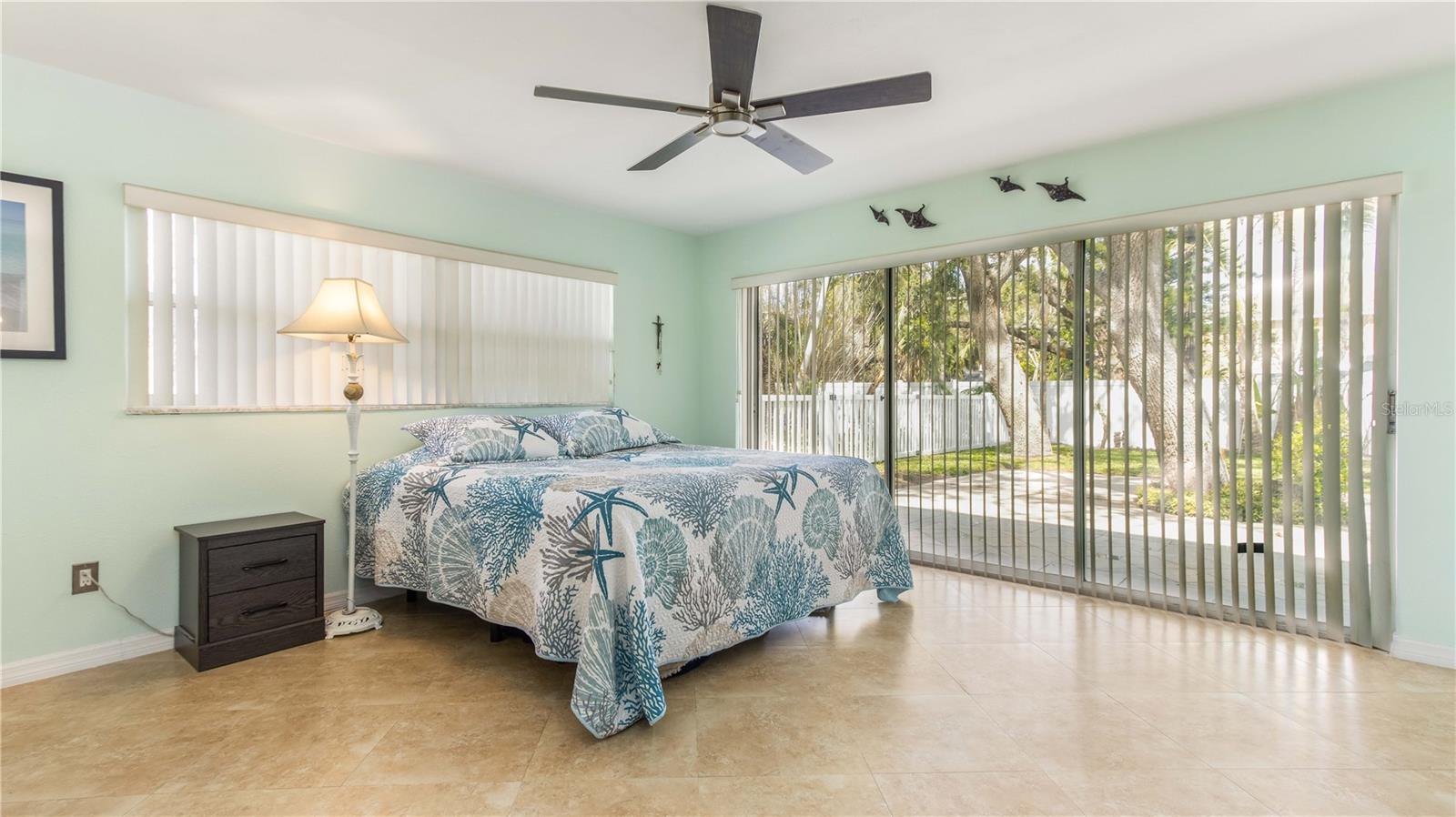 Spacious primary bedroom with sliders out to patio space