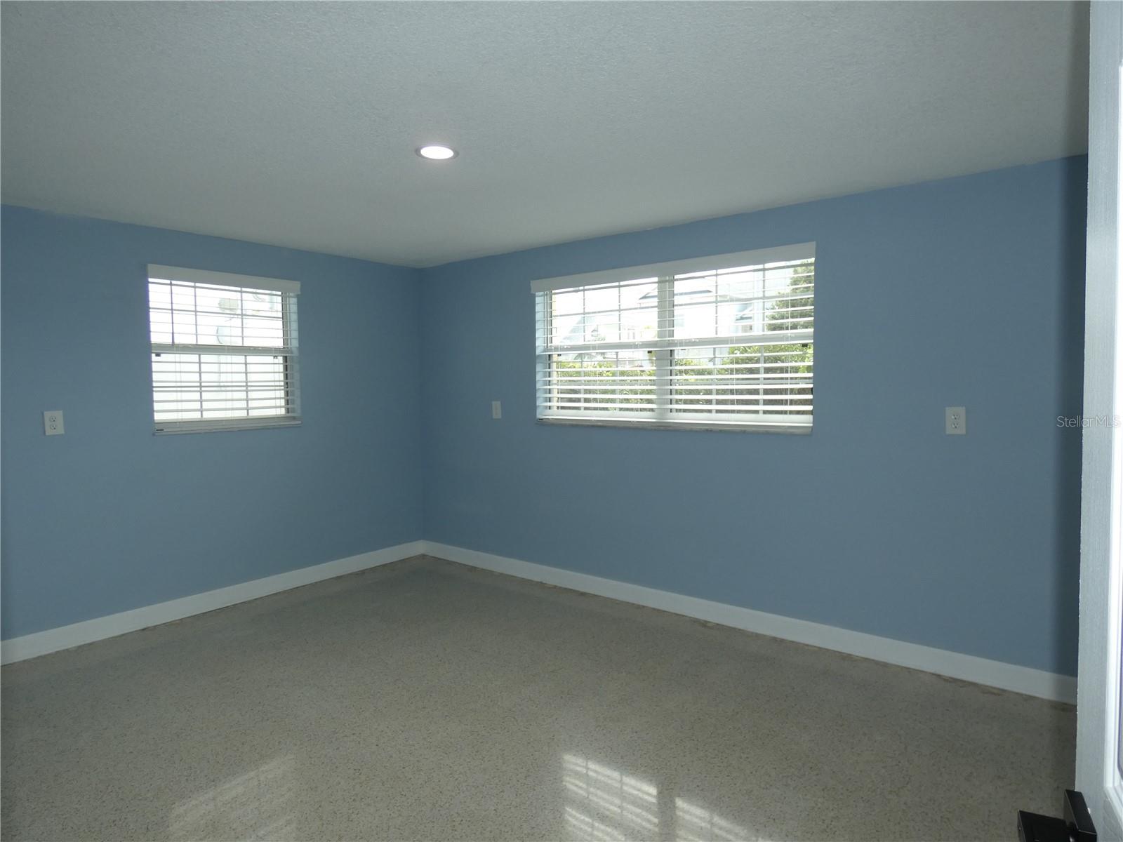 Spacious primary bedroom with terrazzo flooring.