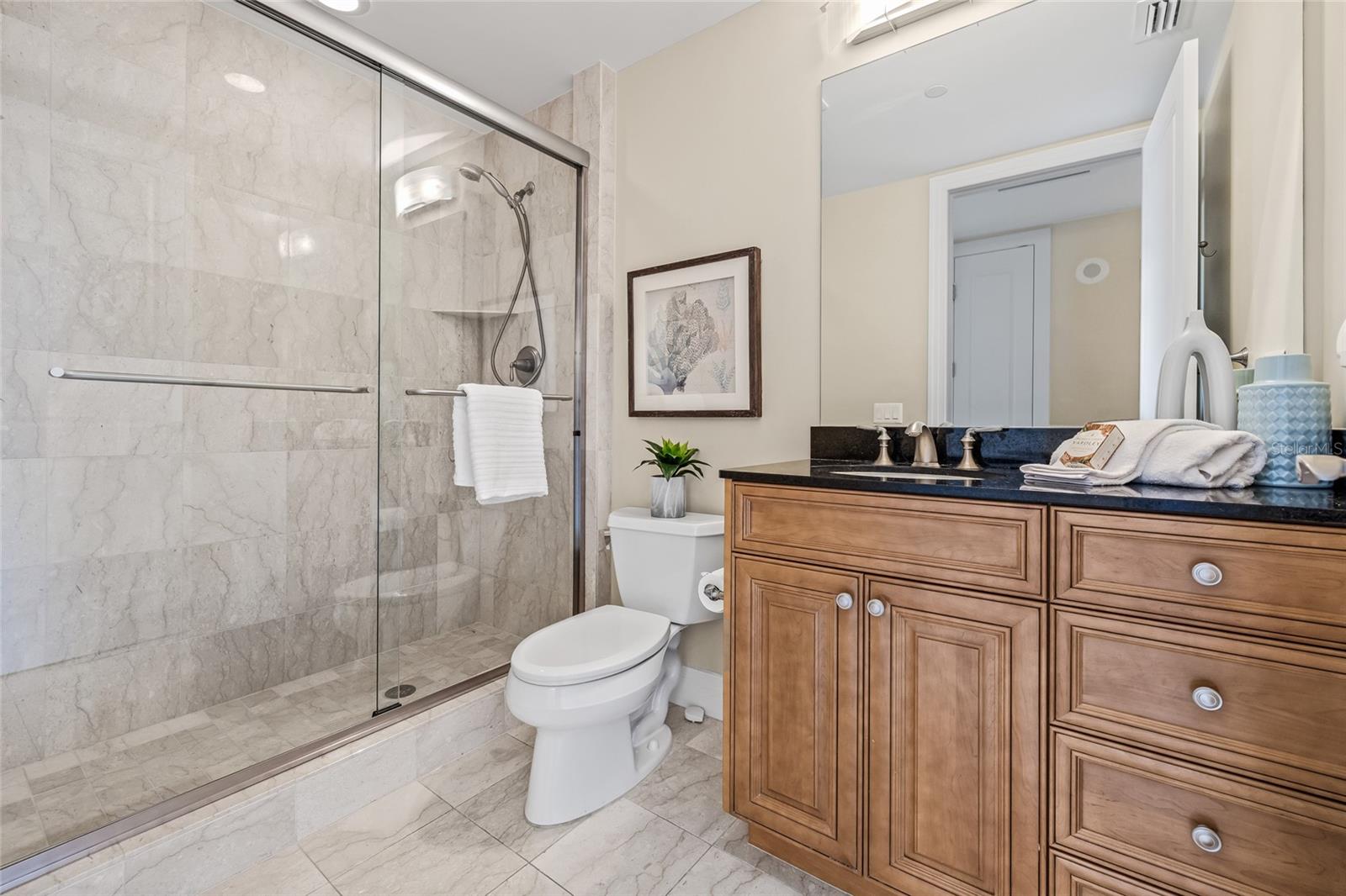 The guest bathroom with a glass-enclosed stand-up shower.