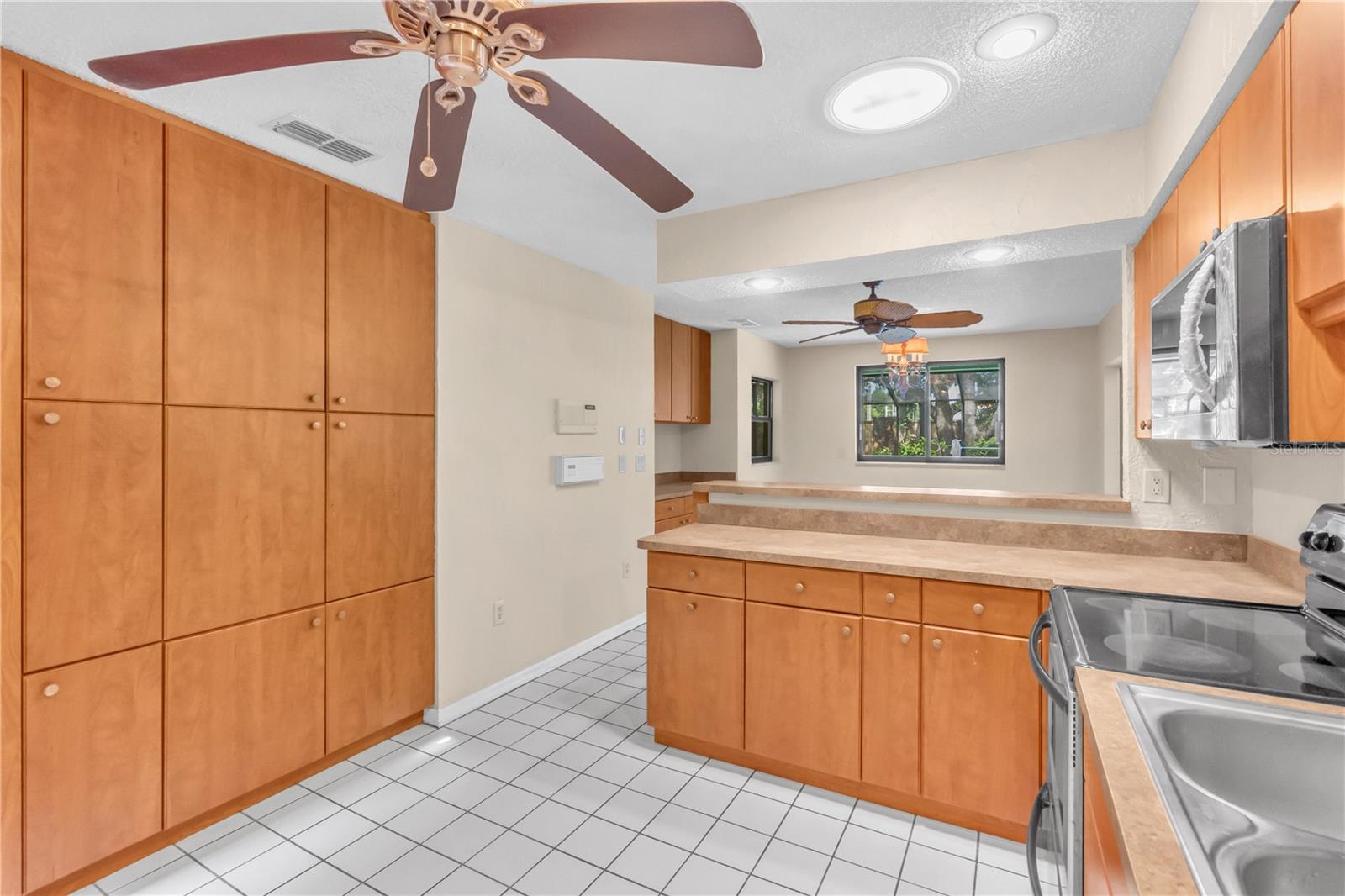 Kitchen with built in Pantry and Storage with ceiling fan and Solar Tube.