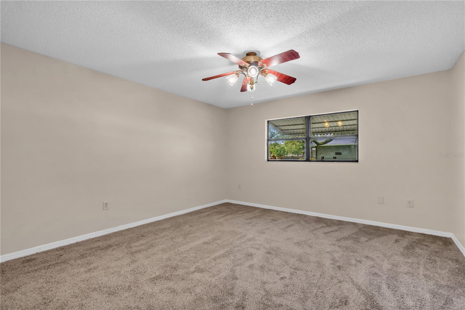 Spacious Bedroom 2 with new carpet, ceiling fan, and walk-in closet.