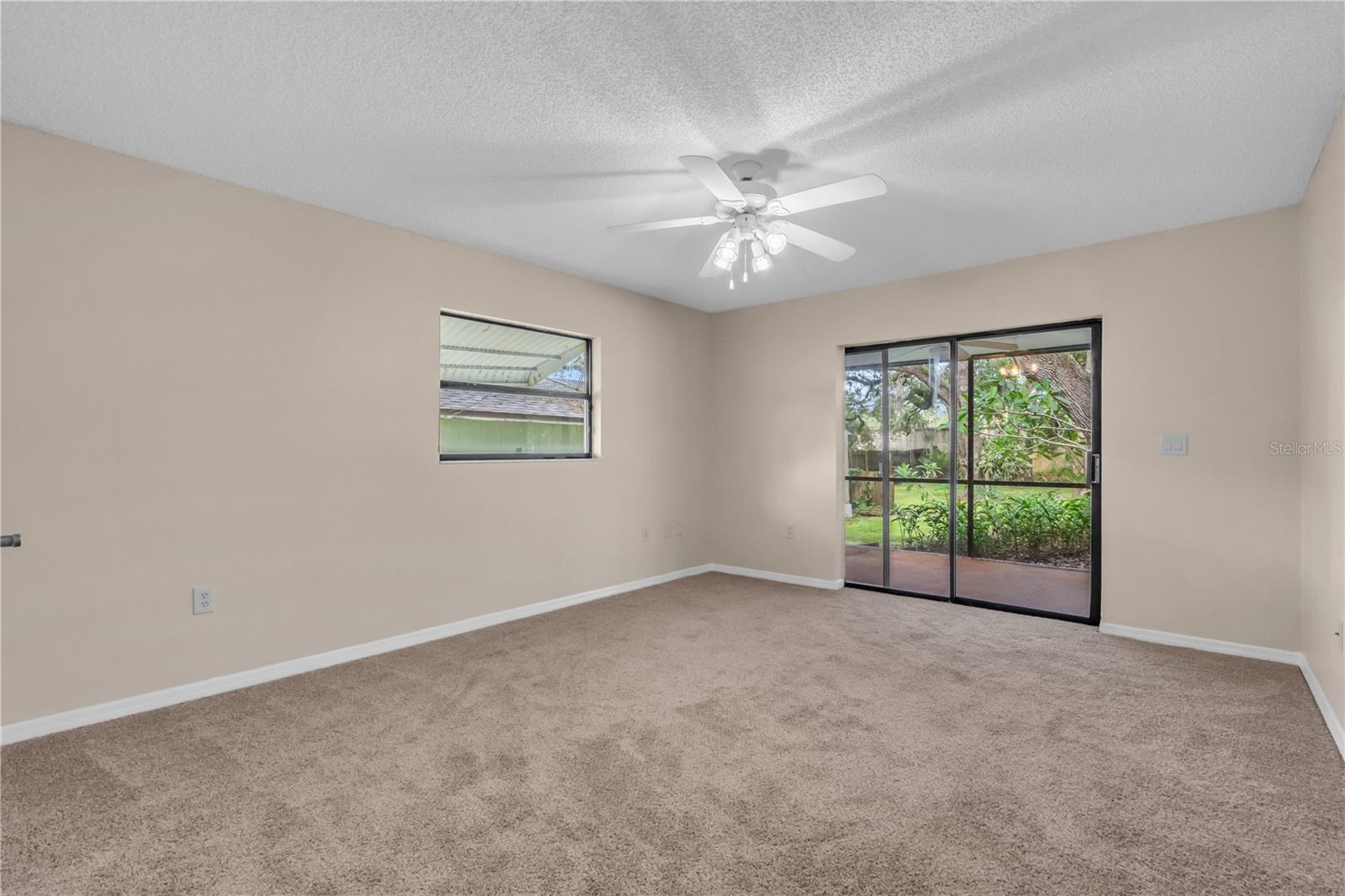 Bedroom 3 with new carpet, ceiling fan, exit to Lanai, and walk-in closet.