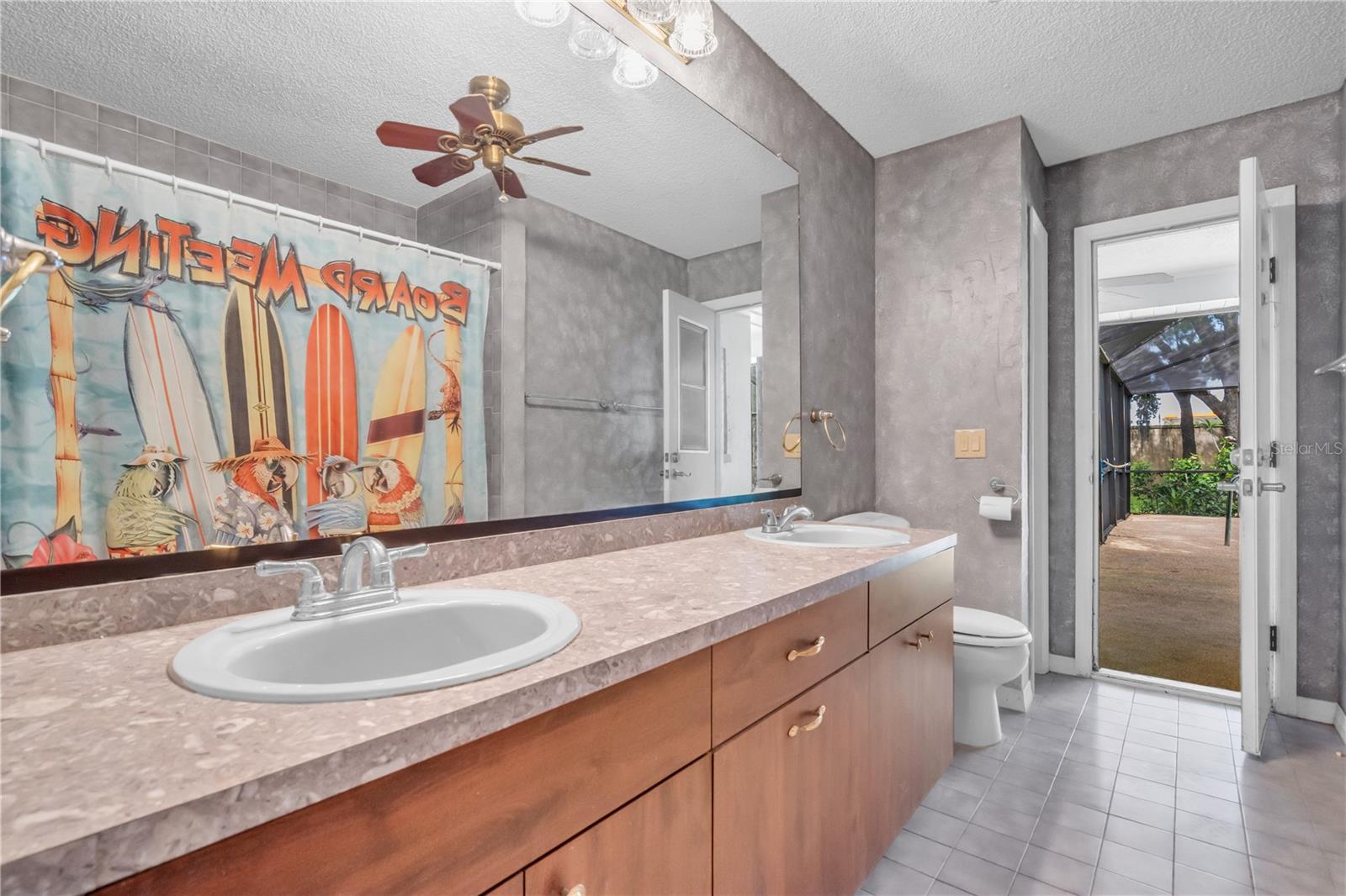 Barthroom 2 with combo shower-tub, dual sinks, and exit to Lanai and pool.