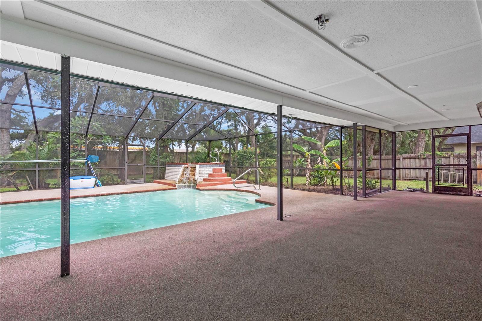 Grand outdoor screened in pool with hot tub. Lots of patio space!