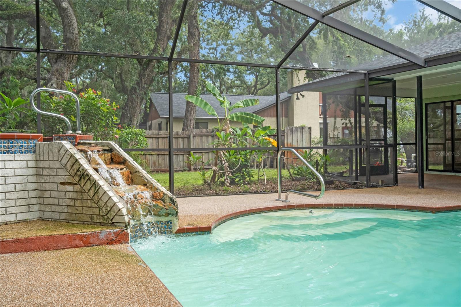 Pool with hot tub that has cascading waterfall.