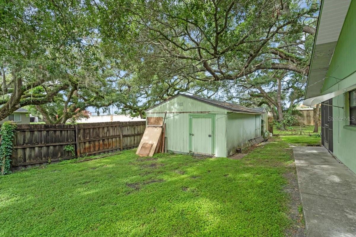 Large shed on the side yard near the garage. Second shed is behind it. Both sheds have new roofs.