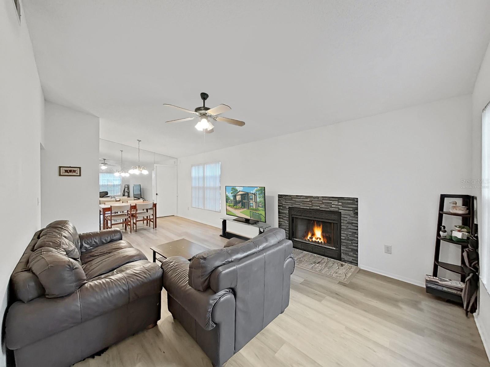 Living Room - Virtually staged items are:  Fire, TV Screen, and Corner Shelve.  Fireplace and TV  are real.