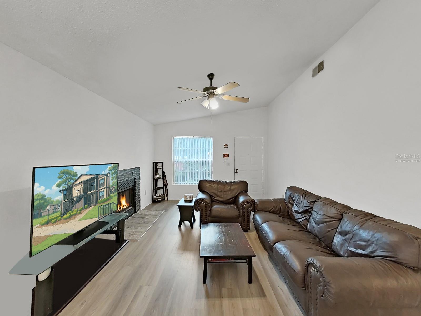 Living Room - Virtually staged items are:  Fire, TV Screen, and Corner Shelve.  Fireplace and TV  are real.