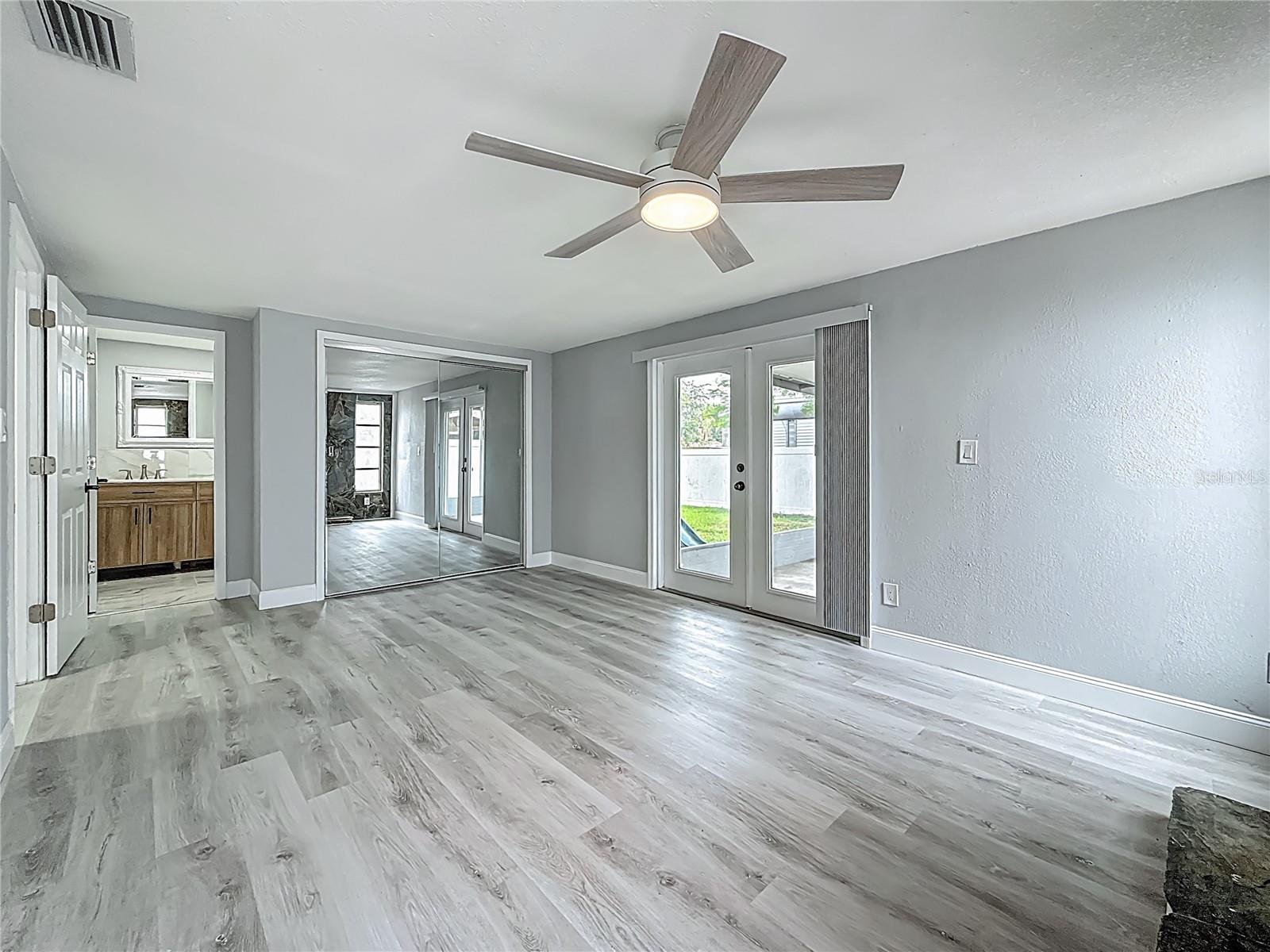Primary Suite with cozy fireplace with private bath and French Doors.  The spacious primary suite also offers flexibility and can easily serve as an additional living area, bonus room, or game room if desired.