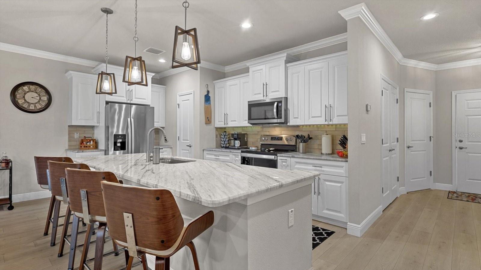 Stone counters and exquisite lighting adorn this chefs kitchen