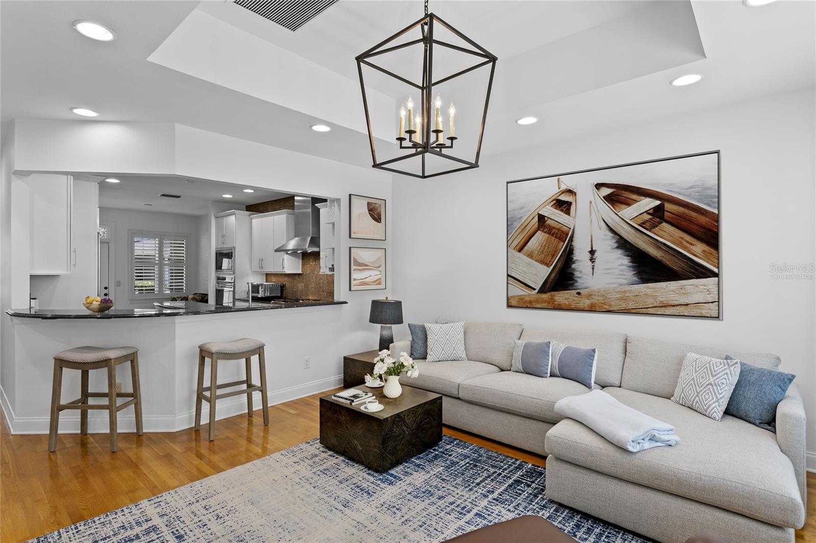 The open layout between the kitchen and family room lets you stay part of the conversation while preparing meals. This is a virtually staged photo of accessories