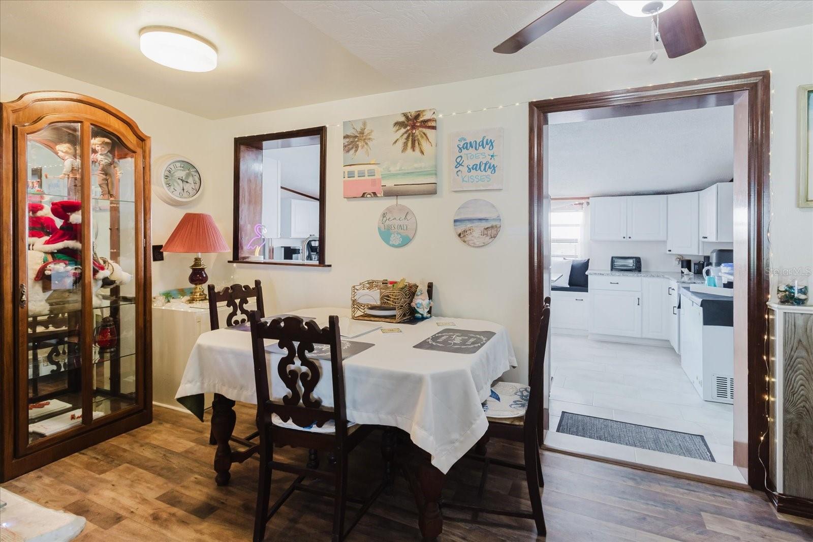 Dining Room With Luxury Vinyl Floors With Doorway To The Updated Kitchen And The Pass Thru That Is At The Kitchen Sink