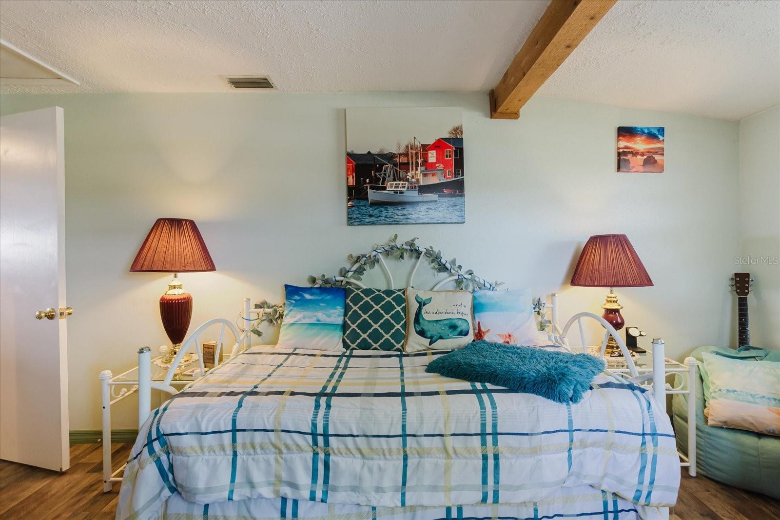 Secondary Bedroom With Luxury Vinyl Floors And Wood Beams