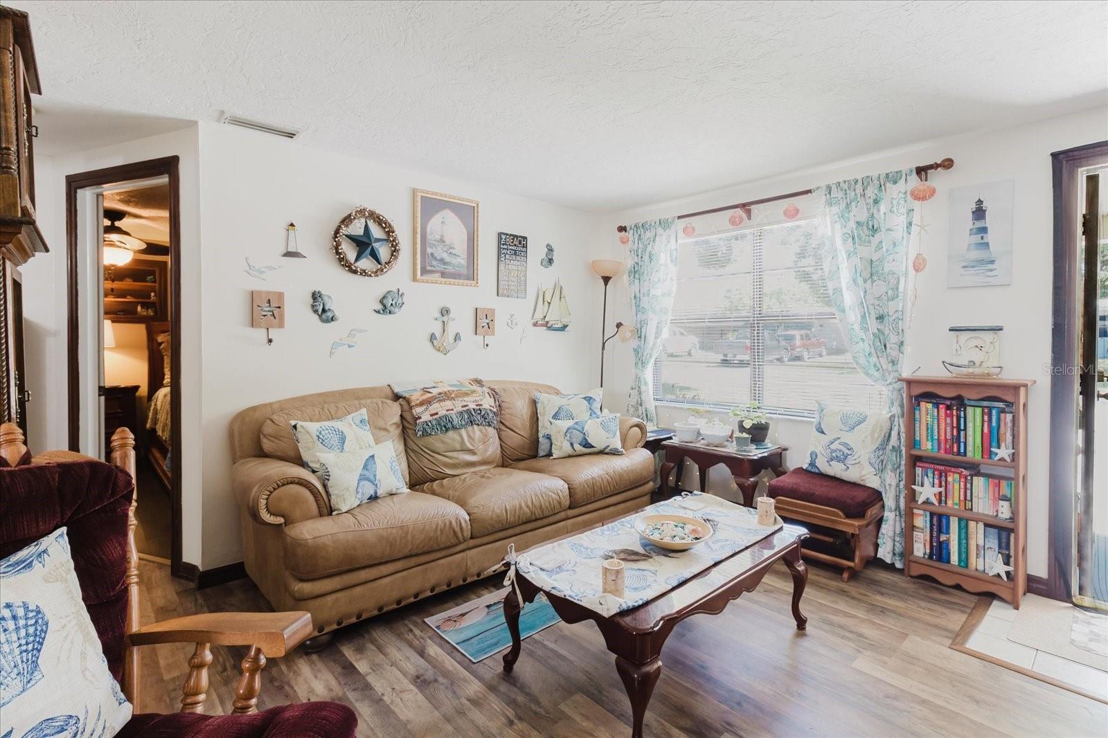 Living Room With View of Front Door. New Luxury Vinyl Floors In May 2025. Primary Bedroom Door Behind The Sofa