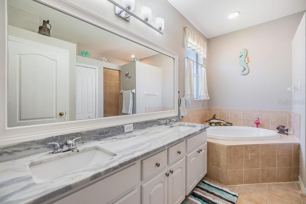 The enviable ensuite bath features a double sink vanity with ample storage and counter space, a soaking tub, walk-in shower, linen closet, and private water closet.