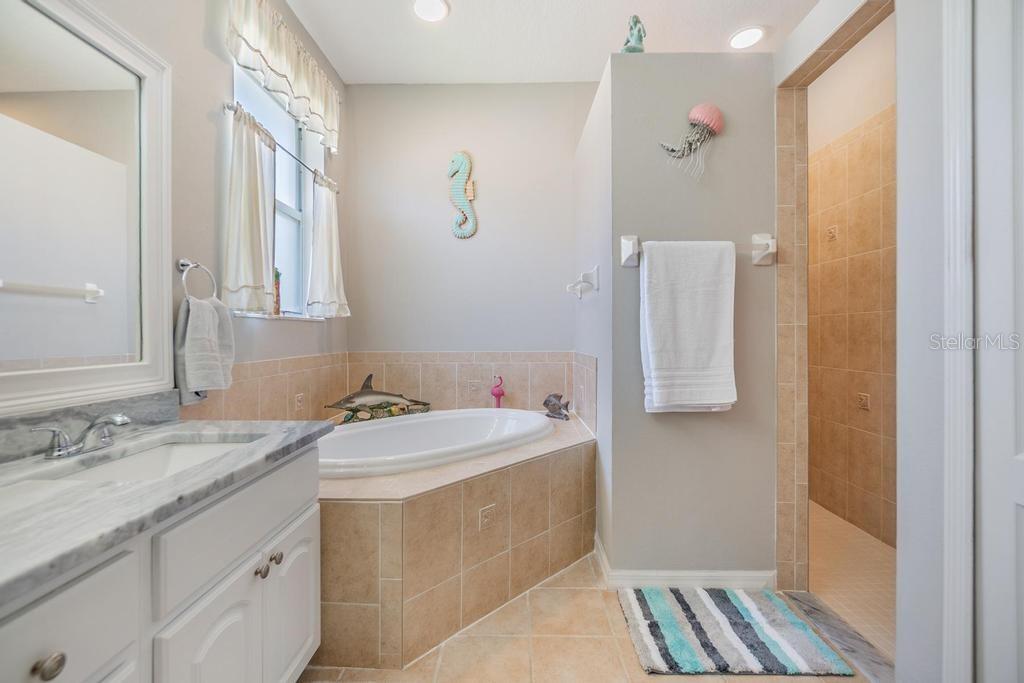 The enviable ensuite bath features a double sink vanity with ample storage and counter space, a soaking tub, walk-in shower, linen closet, and private water closet.