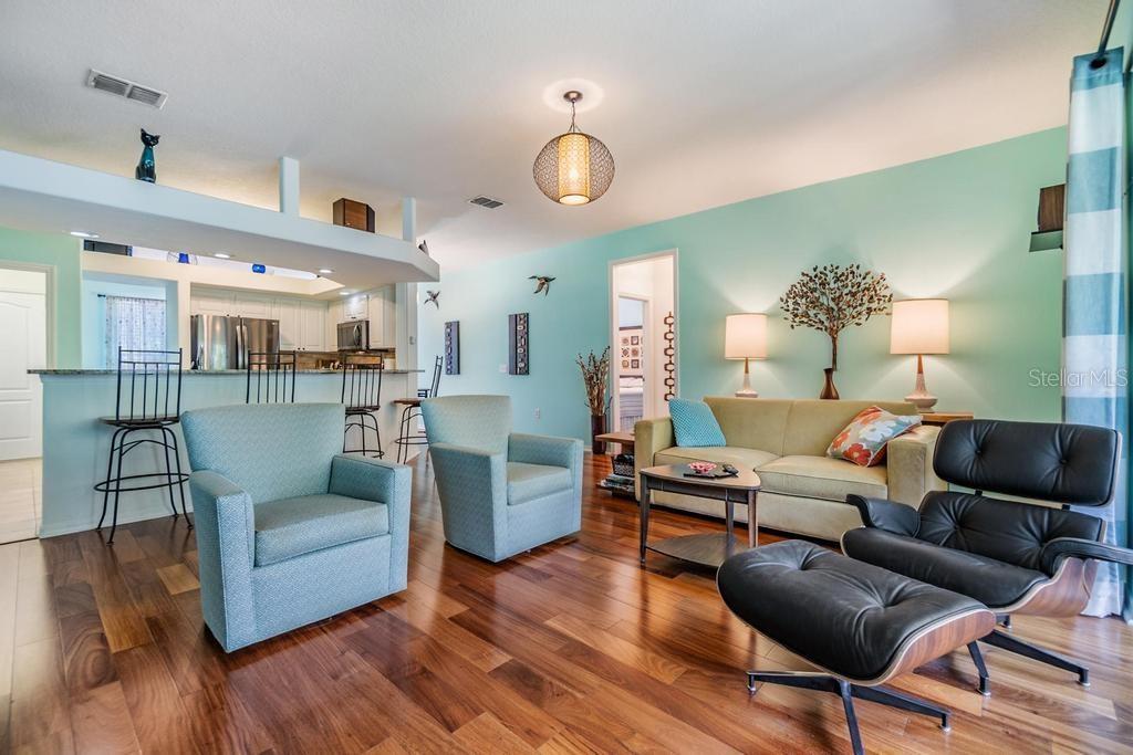 The spacious living room offers a welcoming gathering space and features triple-pocket sliding glass doors that lead to a screened-in patio.