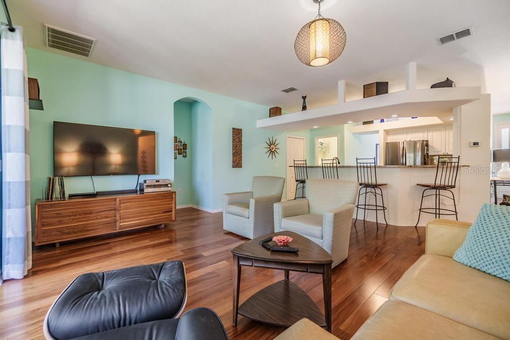 The spacious living room offers a welcoming gathering space and features triple-pocket sliding glass doors that lead to a screened-in patio.