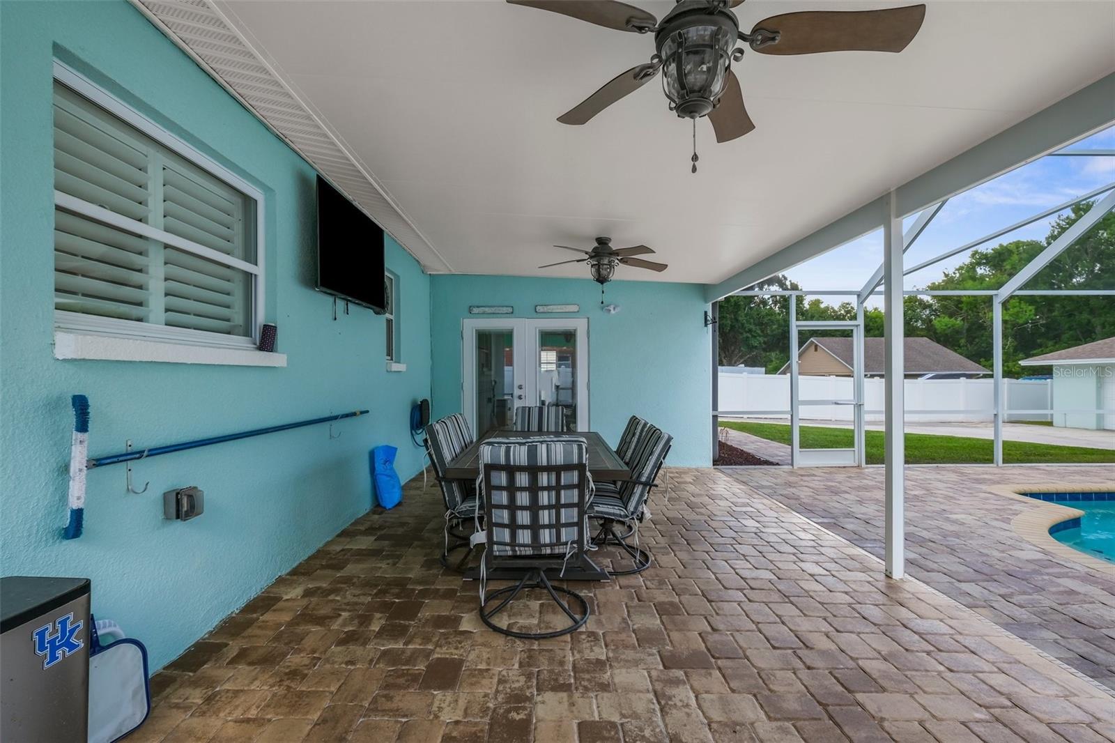 Large covered rear patio by the pool with brick payver deck.