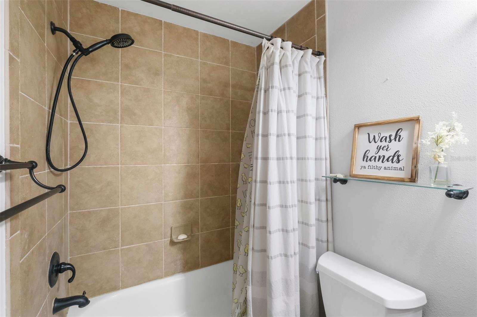 Second bathroom with ceramic tiled tub/shower.