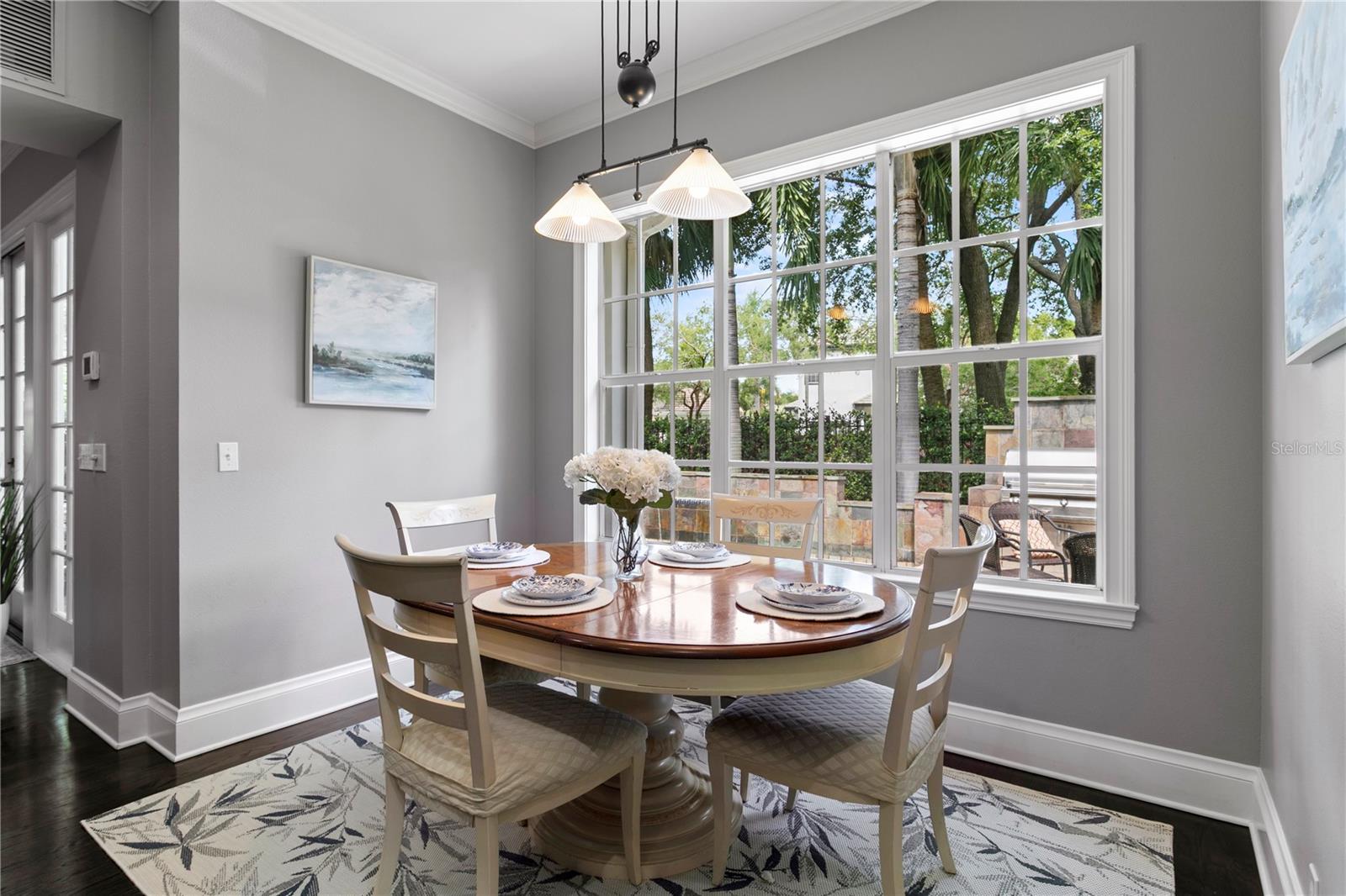 Enjoy informal dining in the kitchen’s cozy eat-in area, offering serene views of the backyard, outdoor kitchen and pool