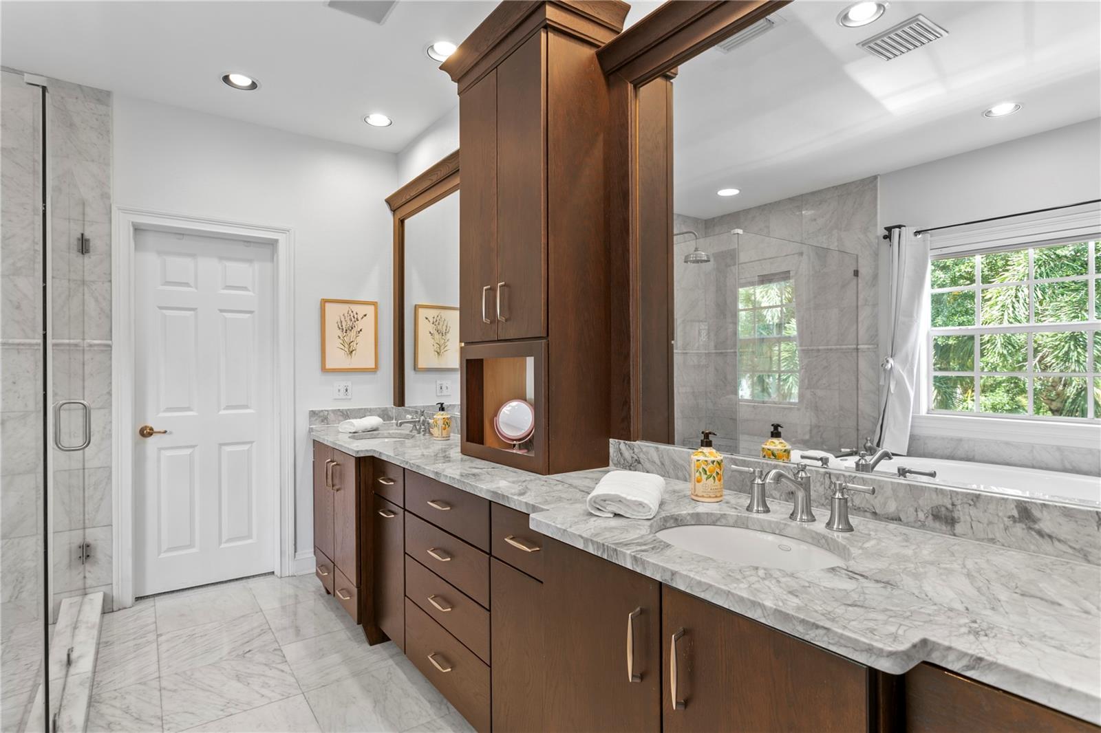 The marble-clad ensuite bath boasts dual vanities, a luxurious soaking tub, and an oversized walk-in shower.