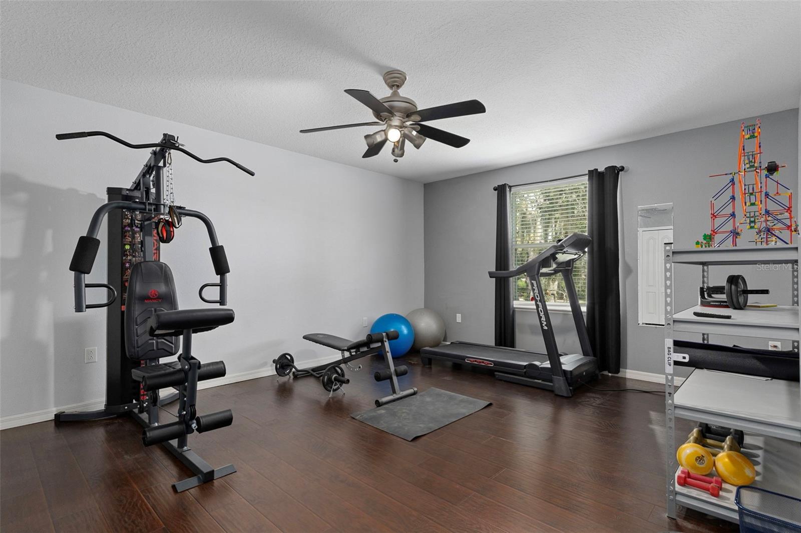 This guest bedroom is very spacious and has beautiful wood floors