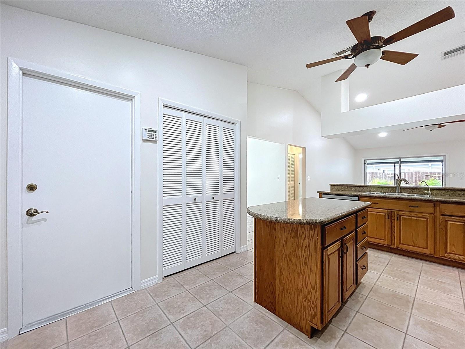 A complete perspective of the open-concept kitchen with custom tile floors, recessed lighting, and abundant cabinetry that ties together style and practicality.