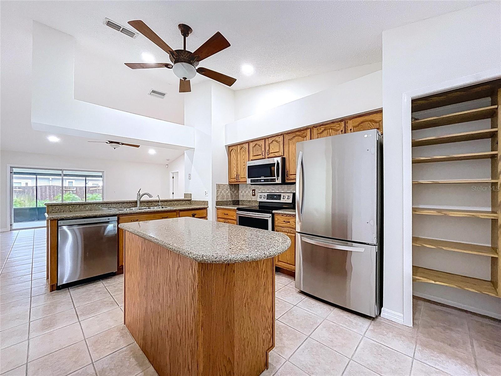 A generous pantry with custom shelving provides excellent storage, just steps from the island and fridge.