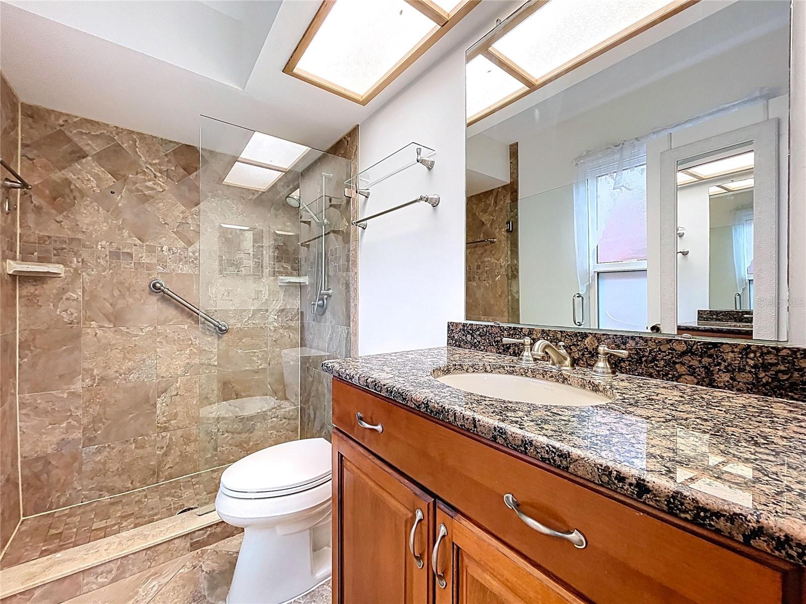 Owner's suite bathroom features walk-on shower and single sink with abundant storage.
