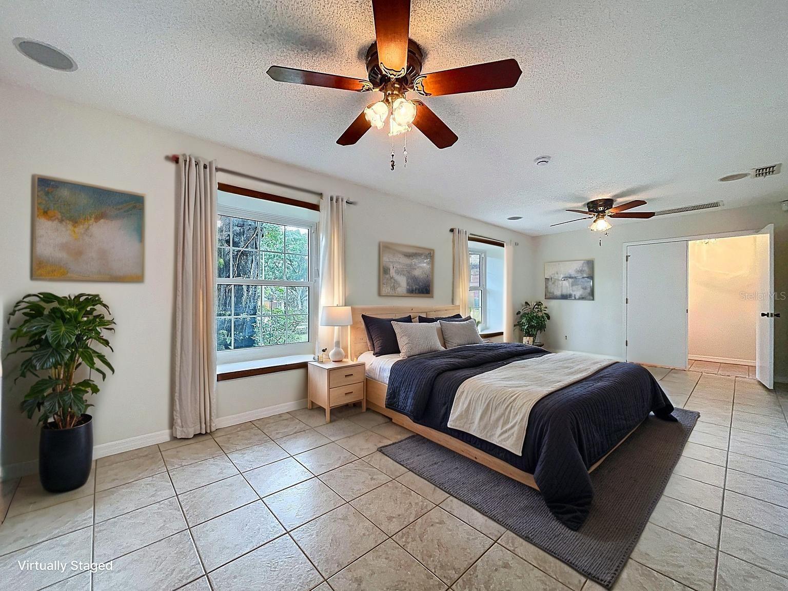 Spacious 24’ x 12’ retreat features double closets, two large windows with built-in window seats, and ceiling fans—perfect as a private guest room or multi-use bonus room.