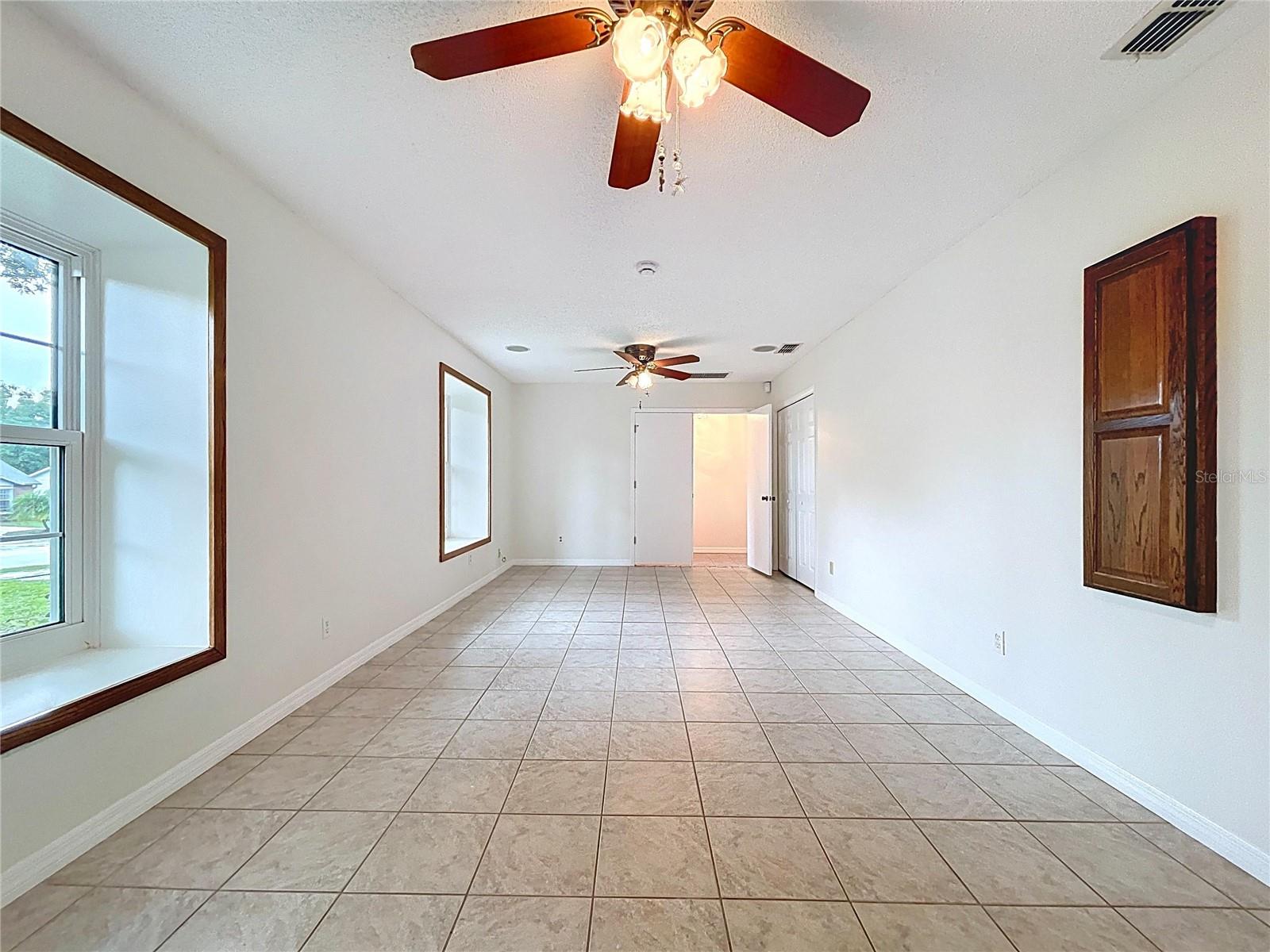 Just off the foyer, this versatile space features tile flooring, dual ceiling fans, and multiple windows for natural light—ideal as a formal living room, home office, playroom, home gym or 3rd bedroom.