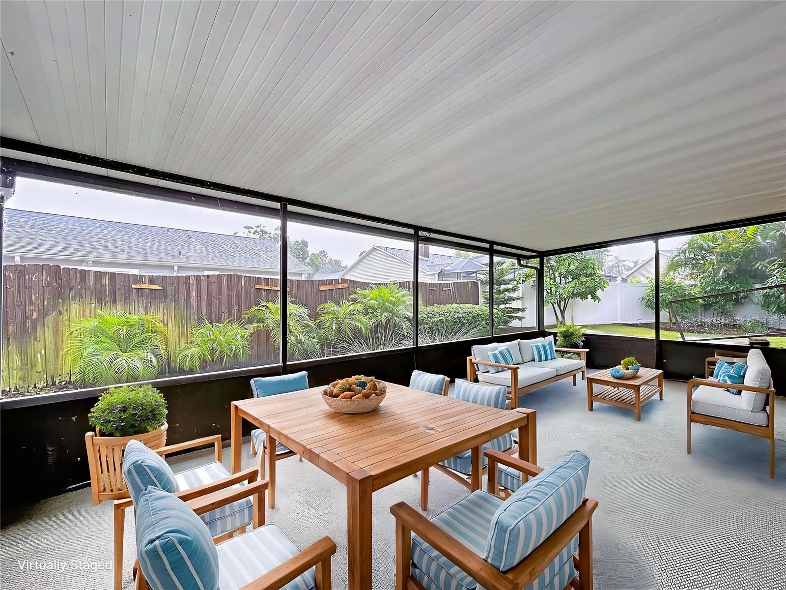 Virtually staged to showcase its entertaining potential, this covered 12x24 screened-in patio offers ample space for outdoor dining and lounging, all overlooking the private backyard.