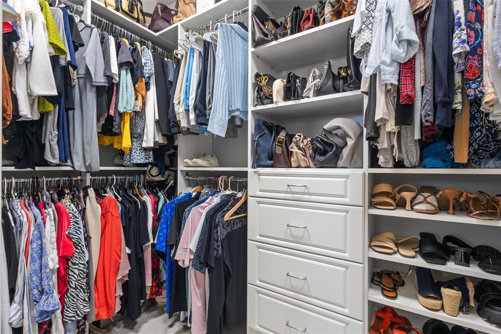 Primary bedroom closet featuring custom built-ins