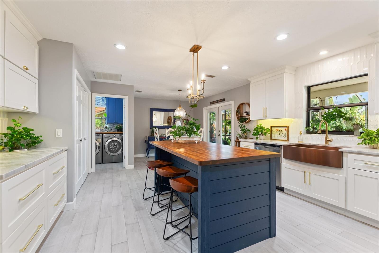 The amazing kitchen with a peek into the laundry room.  The kitchen island seats four and the breakfast nook seats four.  The top of the island is Acadia wood.  This is repeated in the laundry room too!