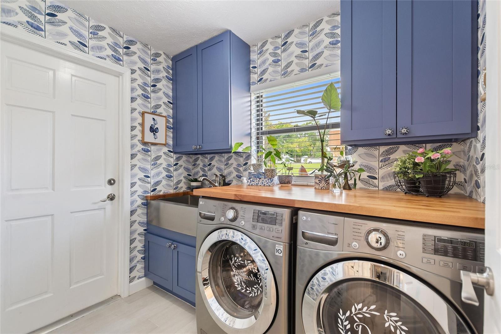 Isn't this laundry room spectacular!  The farm house style sink is such a nice touch and the beautiful Acadia wood countertop compliments the kitchen island top.