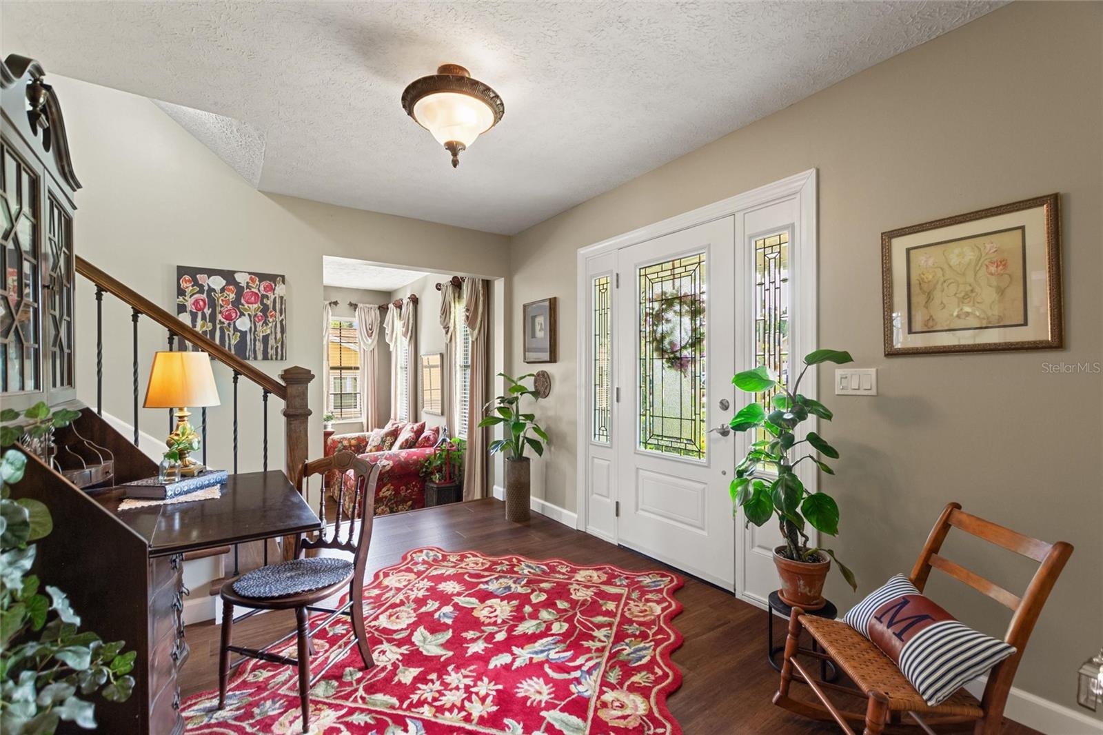 Reverse view showing the front door and the living room off of the foyer.
