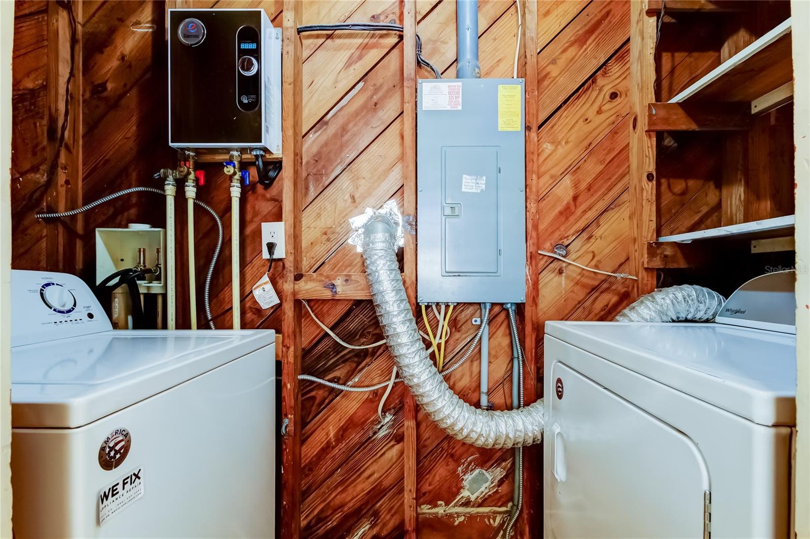Inside utility room. Washer, dryer, tankless water heater and electrical panel.