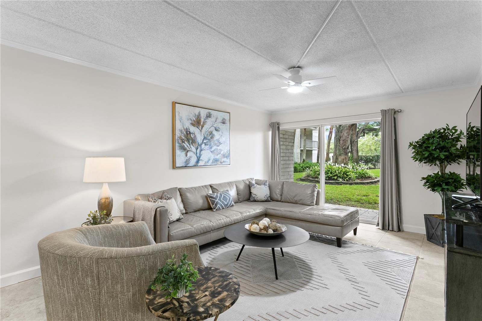 Welcome home - the spacious family room filled with natural light—perfect for unwinding after a long day, with direct access to the porch and serene courtyard views.