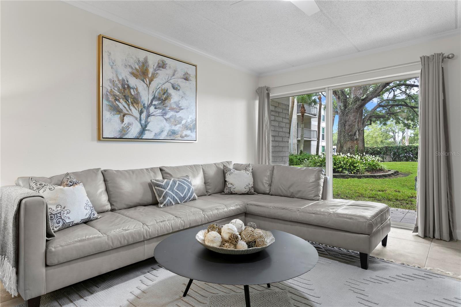 Spacious family room filled with natural light—perfect for unwinding after a long day, with direct access to the porch and serene courtyard views.