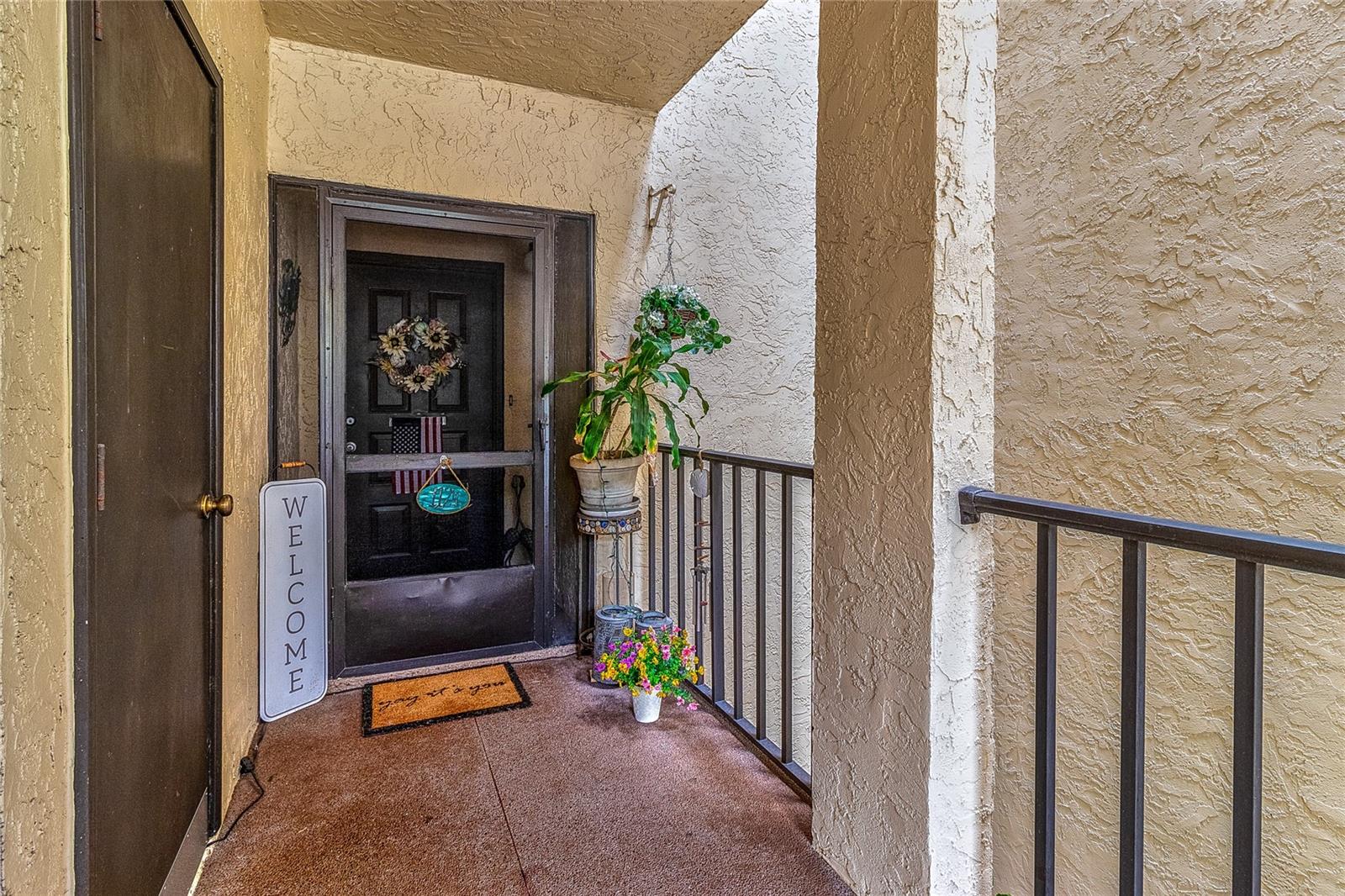 Cozy screened in entryway with easily accessible storage closet.